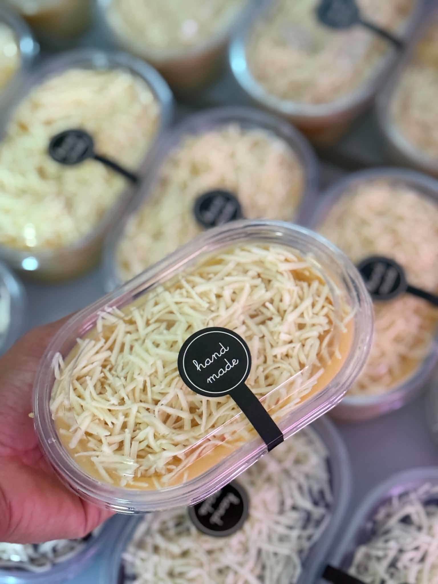 Individual cheesy yema cakes in clear takeaway containers